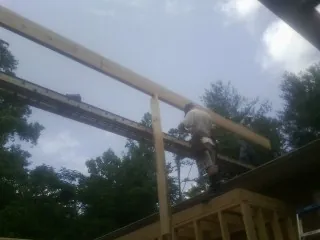 Carpenter setting a ridge beam over a new addition frame — Ice Dam Removal by Roofing Brothers in Milwaukee