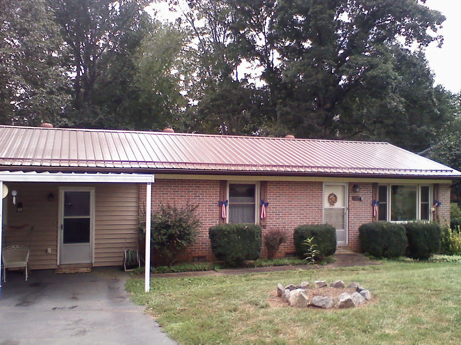 Bronze metal roof and carport on a brick ranch home — Roof Repair work by our crew in Milwaukee